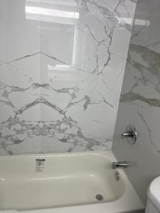 baño con bañera blanca y pared de mármol en The Wayne Inn en Wayne