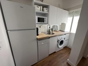 a kitchen with a refrigerator and a washing machine at Abades Suite junto a la Catedral de Sevilla in Seville