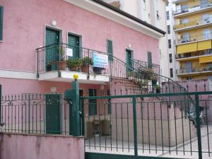 un edificio rosa con balcones y plantas. en Villamareblu, en Ventimiglia