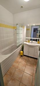 a bathroom with a tub and a sink and a mirror at Villa 78 Alba Rossa Piscine chauffée et Plage de Cupabia in Serra-di-Ferro