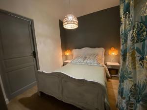 GrandfontaineにあるLe Faucon du Dononのベッドルーム1室(ベッド1台、シャンデリア付)