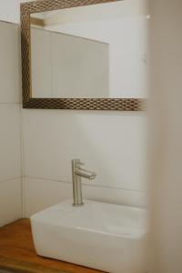 a bathroom sink with a faucet and a mirror at Casinhas da Serena - Casa cacau in Caraíva