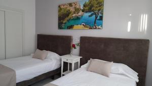 a bedroom with two beds and a painting on the wall at LEVEL Mallorca - Living in Palma de Mallorca