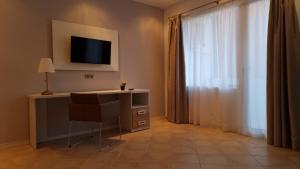 a room with a desk with a television and a window at LEVEL Mallorca - Living in Palma de Mallorca