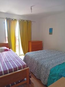 een slaapkamer met 2 bedden en een raam bij Don Fernando in El Quisco