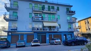 Airbnb Ferentella في تريفيزو: مبنى ازرق فيه سيارات تقف امامه