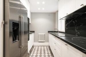 a kitchen with a stainless steel refrigerator and a checkered floor at apartamento exclusivo en GOYA-WIZINK CENTER in Madrid