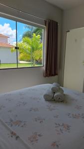 a stuffed animal is sitting on a bed in a bedroom at Suítes Canaã in Capitólio +55 photos