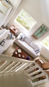 a living room with white furniture and a window at Mansao Angra Pe na Areia in Angra dos Reis