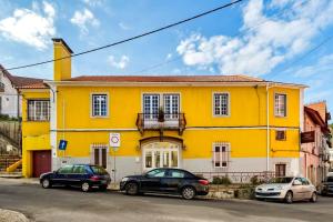una casa gialla con macchine parcheggiate di fronte di Casa Amarela de Sintra II a Sintra