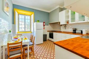 una cucina con un tavolo e un frigorifero bianco di Casa Amarela de Sintra II a Sintra