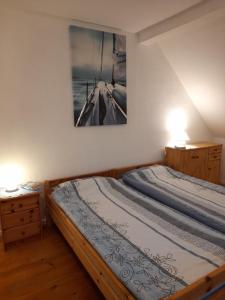 - une chambre avec un lit et une photo sur le mur dans l'établissement Gemütliche Ferienunterkunft direkt am Meer, à Holnis