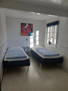 2 camas en una habitación con 2 ventanas en Stokrosen, en Åkirkeby