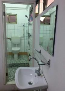a bathroom with a sink and a toilet and a mirror at HotelMidnight78 in Paramaribo