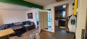 a living room with a couch and a guitar on the wall at Small Lake Apartment in Bergisch Gladbach