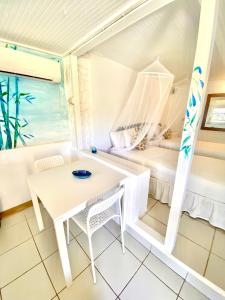 a room with a table and a bed at Blue Bamboo cottage Marigot Bay. in Marigot Bay