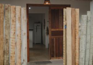 une chambre avec une porte s'ouvrant sur une chambre avec un réfrigérateur. dans l'établissement Casinhas da Serena - Casa concha, à Caraíva