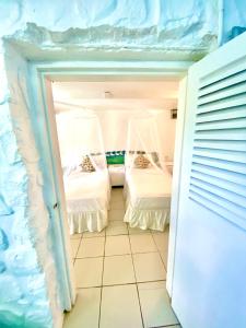 Habitación pequeña con 2 camas en una habitación en Blue Bamboo cottage Marigot Bay., en Bahía Marigot