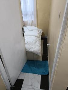 ein kleines Zimmer mit einer Tür mit einem Bett und Handtüchern in der Unterkunft D.S Apartment in Kakamega