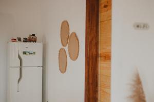 uma cozinha com um frigorífico branco e uma parede com um frigorífico. em Casinhas da Serena - Casa concha em Caraíva