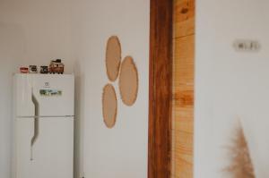 a kitchen with a white refrigerator and a wall withmbermbermbermbermbermber at Casinhas da Serena in Caraíva
