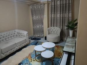 ein Wohnzimmer mit einem Sofa und 2 Tischen in der Unterkunft D.S Apartment in Kakamega