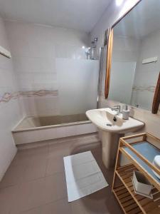 a bathroom with a tub and a sink and a bath tub at Primera Linea del Mar - Acceso Directo Playa Carihuela in Torremolinos