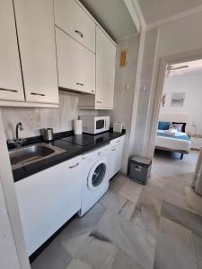 a kitchen with a sink and a washing machine at Primera Linea del Mar - Acceso Directo Playa Carihuela in Torremolinos