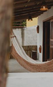 una hamaca colgada del techo de una habitación en Casinhas da Serena - Casa concha en Caraíva