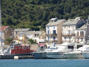 un grupo de barcos atracados en un puerto con casas en Gîtes Santa Maria Cap Corse, en Macinaggio
