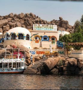 un barco está atracado frente a un edificio en Old Nubian guest house, en Asuán