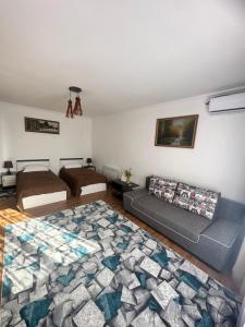 uma sala de estar com duas camas e um tapete em "Гостевой дом Анны" по улице Абая, 165 em Taldykorgan