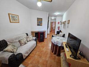ein Wohnzimmer mit einem Sofa und einem Flachbild-TV in der Unterkunft Corralazo A in Calasparra