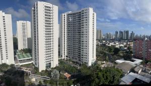 um grupo de altos edifícios brancos em uma cidade em Apartamento 2 quartos 1km da Praia no Recife