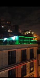 White Palace Hotel في إسطنبول: مبنى عليه اضاءة خضراء في الليل
