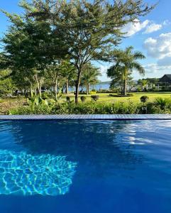 una piscina azul con árboles en el fondo en Lira Boutique Lodge en Thohoyandou