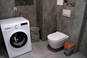 a bathroom with a washing machine and a toilet at Triple A Apartments in Sarajevo