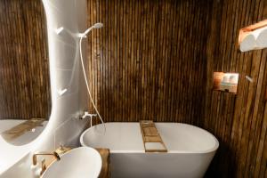 een badkamer met een bad, een toilet en een wastafel bij Blue Harmony Apartment in Floreşti