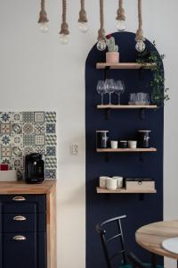 a kitchen with a blue wall with shelves at Blue Harmony Apartment in Floreşti