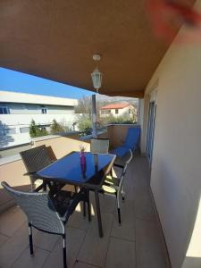 a blue table and chairs on a balcony at Čalić in Seline