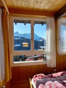 1 dormitorio con ventana y vistas a la montaña en Le Perchoir, en Gryon