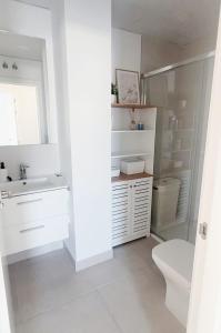 ein weißes Badezimmer mit Waschbecken und Toilette in der Unterkunft Ático Ceitil Candor in Rota
