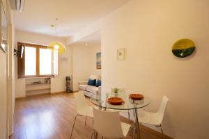 a living room with a glass table and white chairs at Amalfi e Positano Home in Salerno