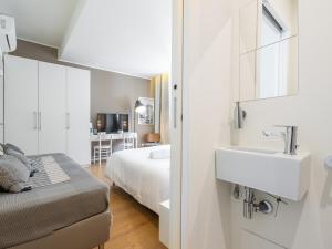 a white bathroom with a sink and a bed at Dome in Cagliari