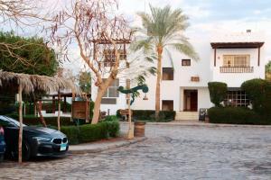 une voiture garée devant une maison avec des palmiers dans l'établissement Delta Sharm, between Old Market& Naama Bay, center, à Charm el-Cheikh