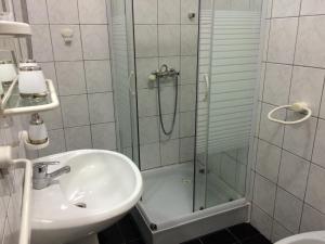 bagno con doccia in vetro e lavandino di Apartments Ferreri a Maslenica