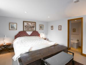 a bedroom with a large bed with a wooden headboard at The Cow Shed in Quatford