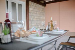 uma mesa com pratos, copos e garrafas de vinho em Apartment Martin-nearby Krka National park em Kaočine