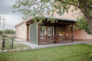 uma pequena casa com um alpendre num quintal em Apartment Martin-nearby Krka National park em Kaočine