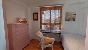 a bedroom with a bed and a desk and a dresser at Precioso apartamento a 7 minutos en tren al centro de Valencia in Benetúser